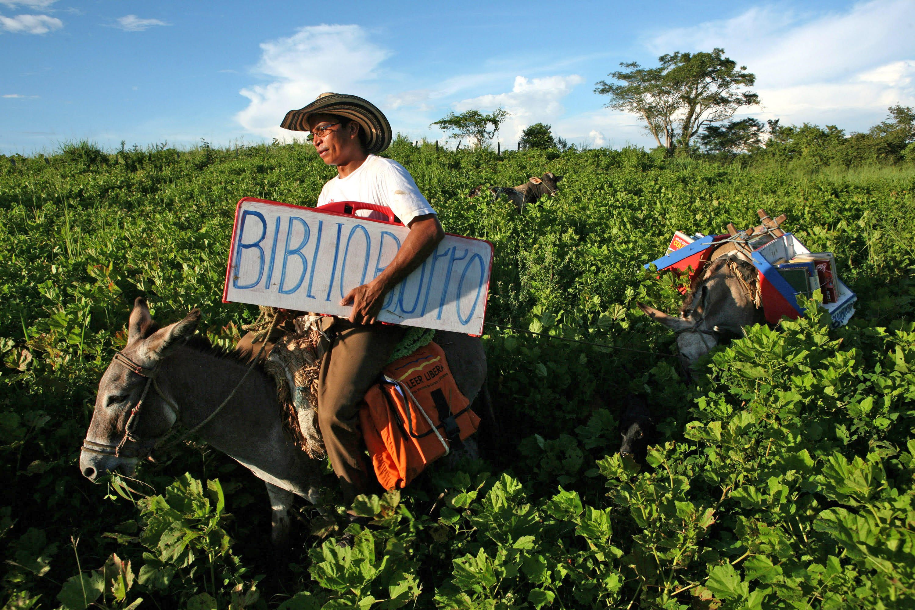 Burros Alfa and Beto, seen here with Luis Soriano in 2008, have been helping the teacher deliver books for more than 20 years.