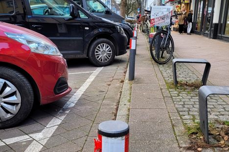 Bollard with visible car impact marks.