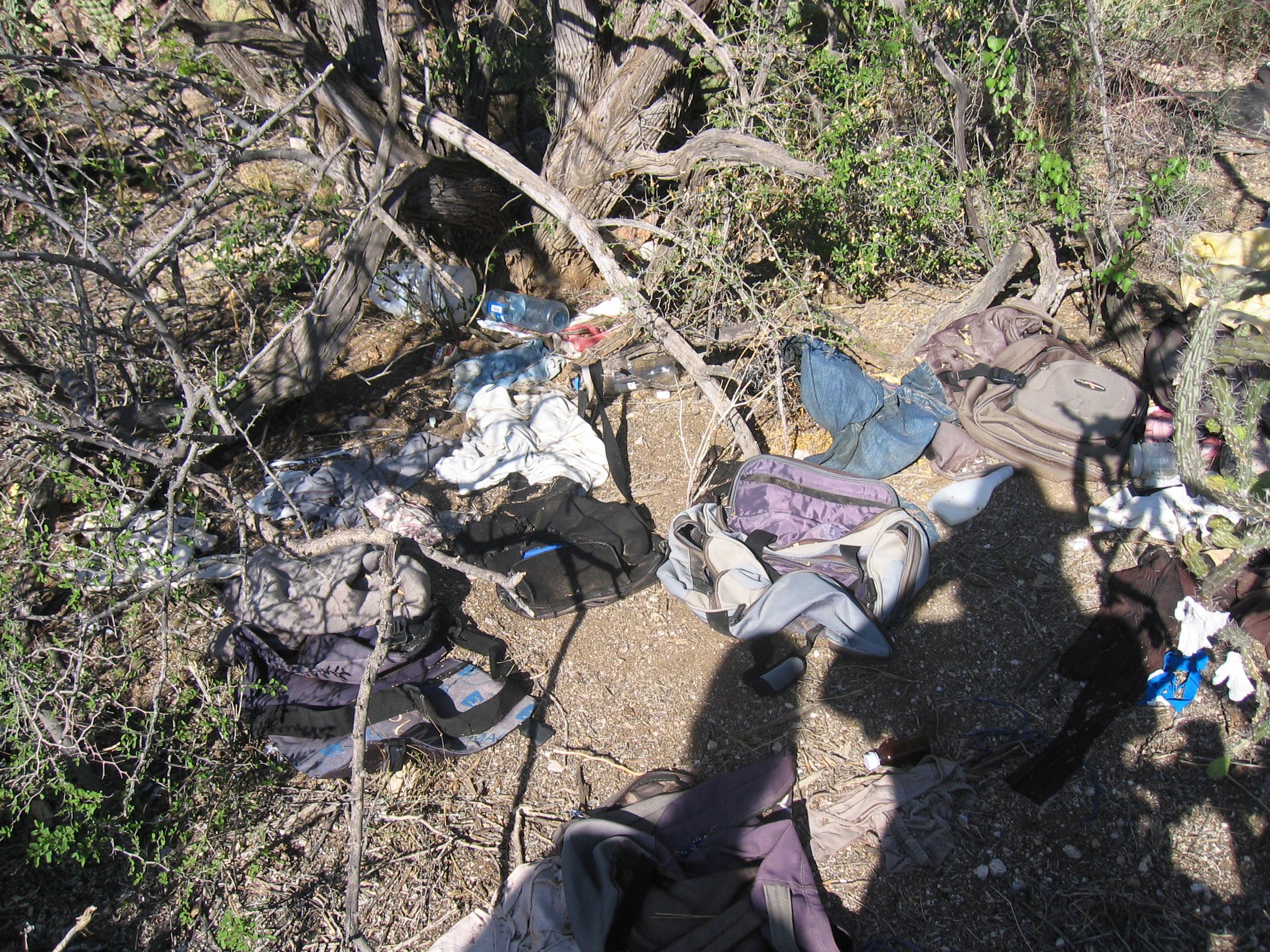 A site in the Arizona desert is seen, covered by clothing and other trash believed to be left behind by migrants.