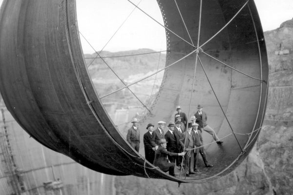 Members of the Boulder City Consulting Board and other officials standing in a section of pipe over the Hoover Dam, 1935.