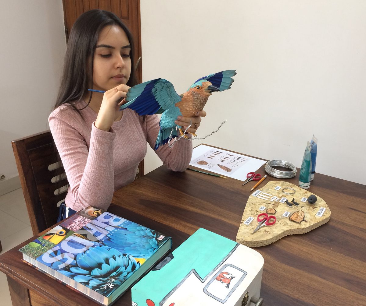 Niharika Rajput works on a sculpture of an Indian roller.