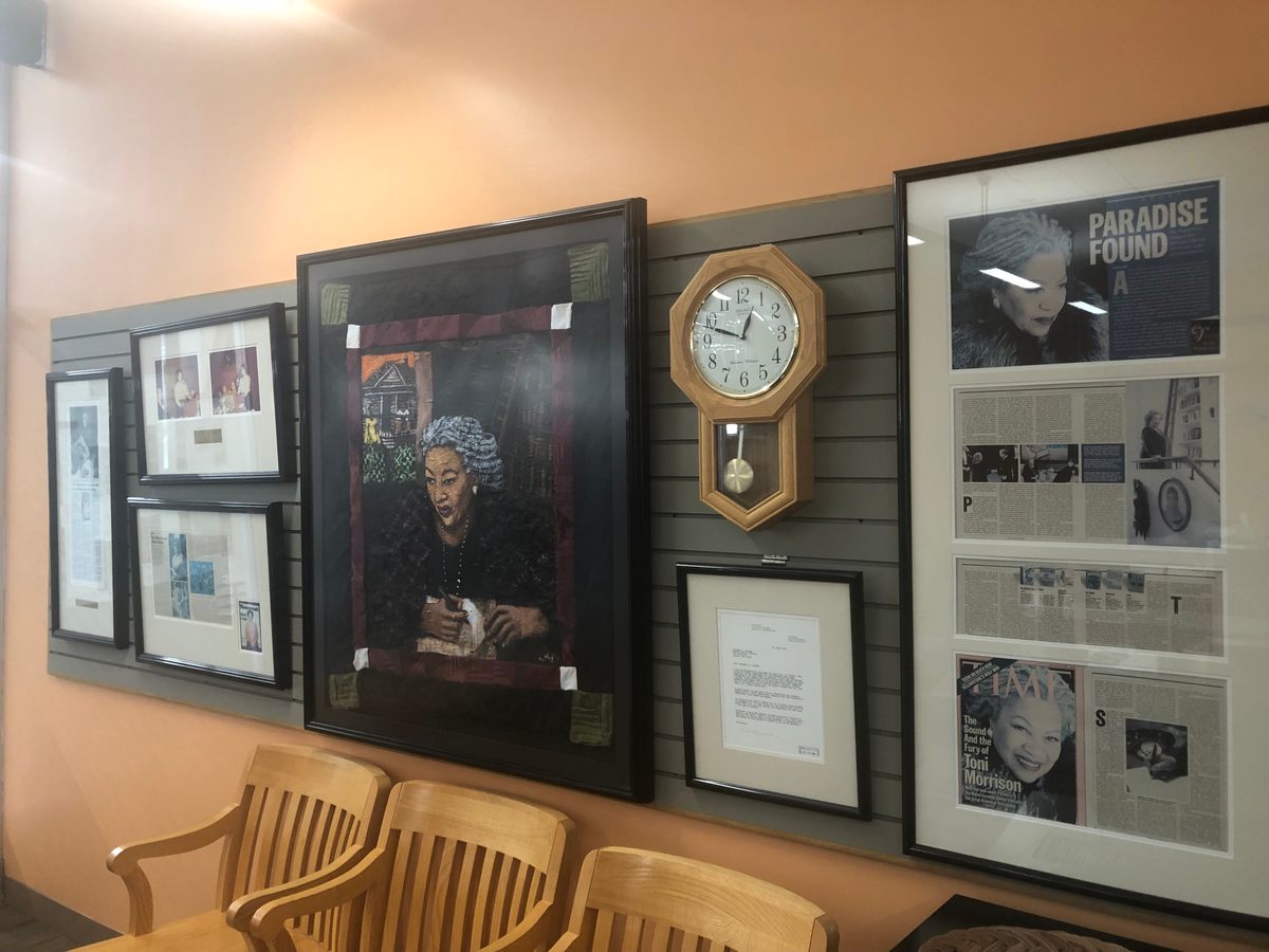 The reading room features a wall of magazine covers, newspaper clippings, and a quilt square of Morrison at work.