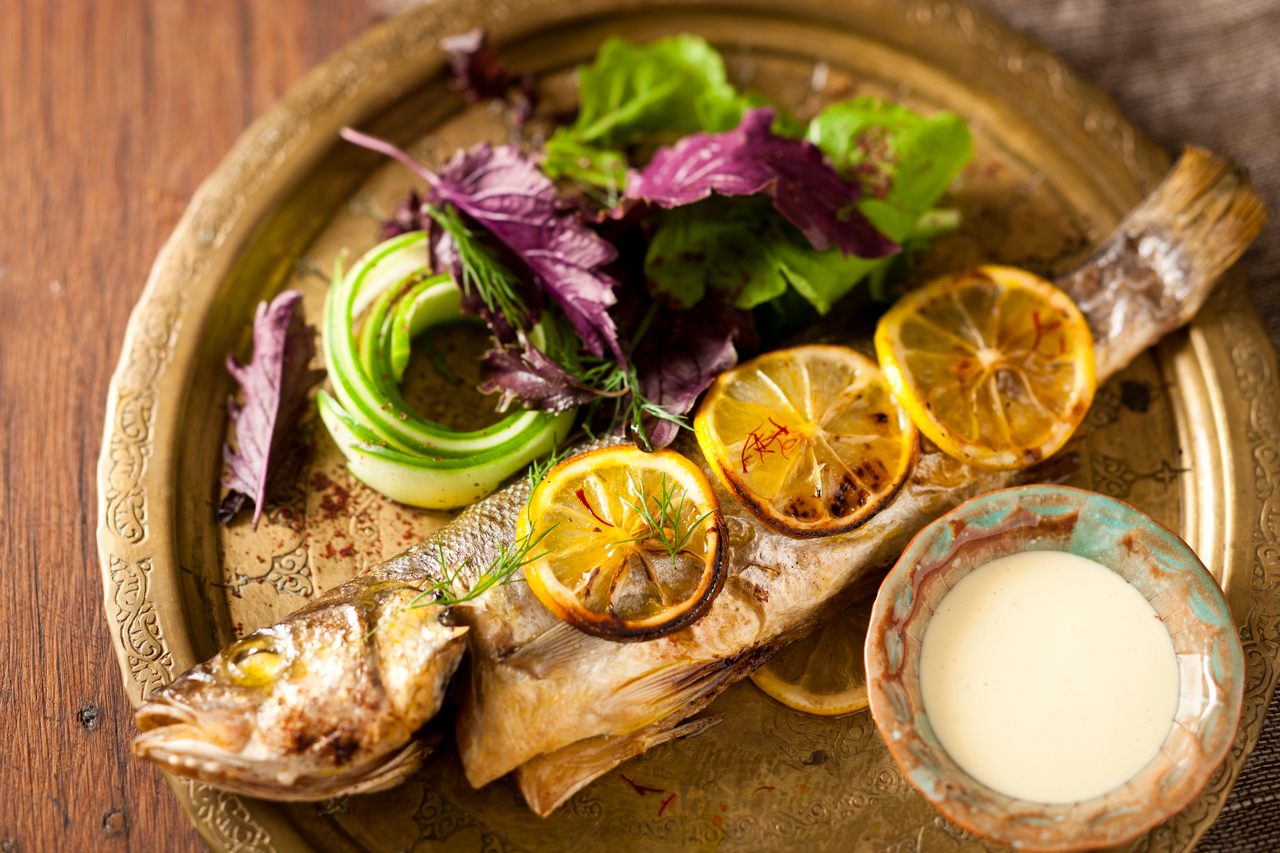 A saffron and rose water dressing lends unexpected perfume to a roasted sea bass stuffed with walnuts. 