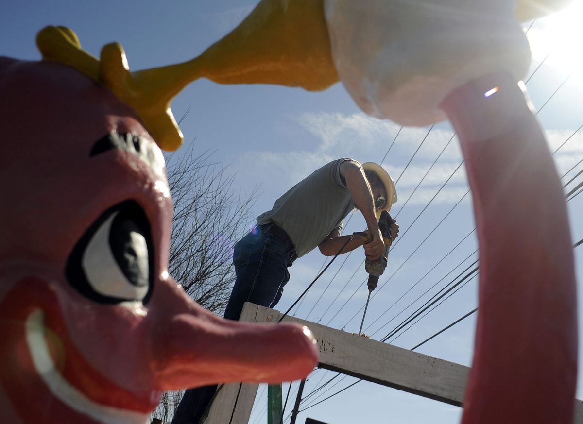 Mark Cline drills holes before mounting his eight-foot hotdog creation atop the sign for Boardwalk Cafe just outside Waynesboro, Virginia, on Wednesday, March 17, 2010.