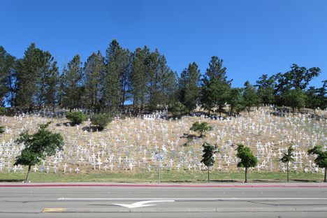 Crosses and other religious symbols dot the hillside opposite the BART station. 