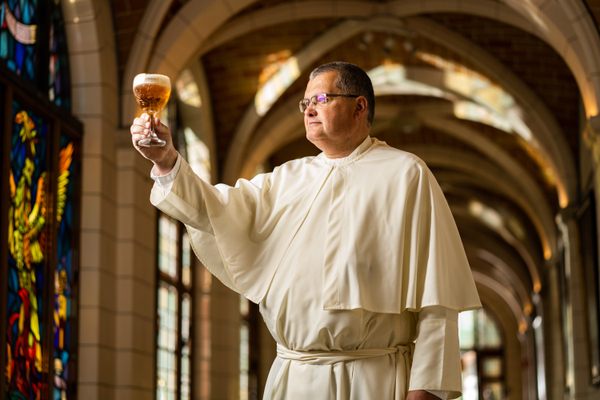 Father Karel Stautemas raises a glass.