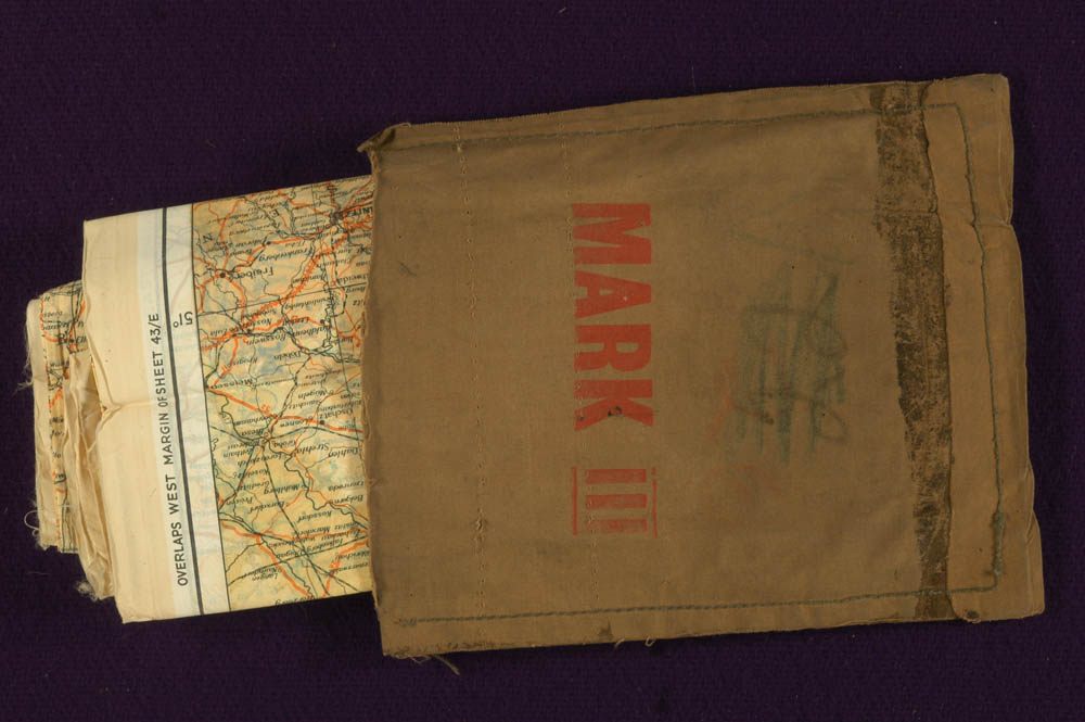 A "Mark III" military escape kit, with a silk map peeking out.
