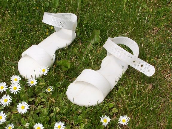 A pair of children's shoes Bowyer printed with RepRap. When the kid outgrows the shoes, Bowyer says, "you could chuck the shoes back into the reprocessor, throw in an extra milk bottle, and print out a bigger pair."