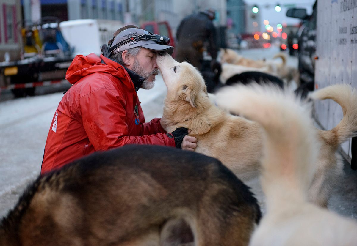 Scott Janssen, also known as The Mushing Mortician, greets each of his dogs before the 2015 ceremonial start.
