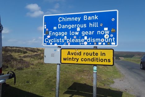 Warning sign at the top of the hill now adorned with numerous  stickers