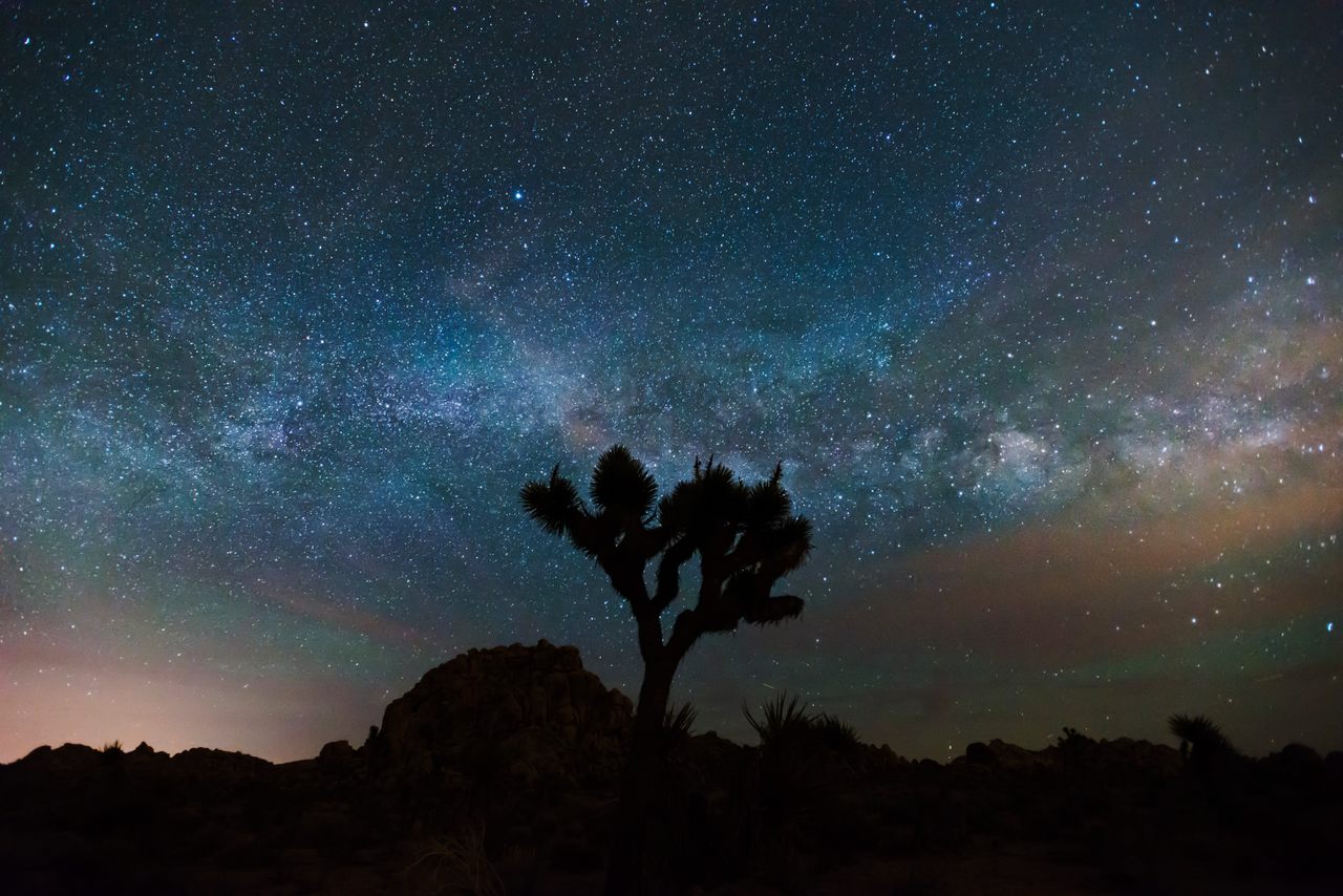 The Milky Way, as seen from Joshua Tree National Park, is framed by airglow, red and green bands created when solar radiation energizes atoms and molecules of air.