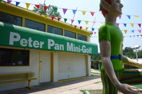 A brightly-colored statue of Peter Pan stands at the entrance.