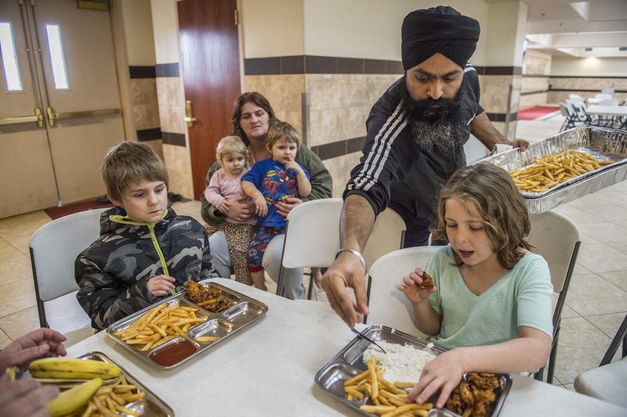 At a Sacramento gurdwara, Amarjit Singh dishes up food to a family forced to evacuate under the threat of a catastrophic dam spillway collapse in 2017.