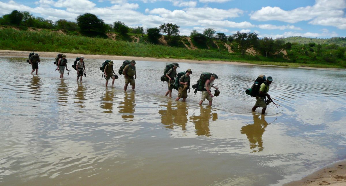 Tourists on a guided wilderness hike cross the Mfolozi River in KwaZulu-Natal province, in northwestern South Africa.