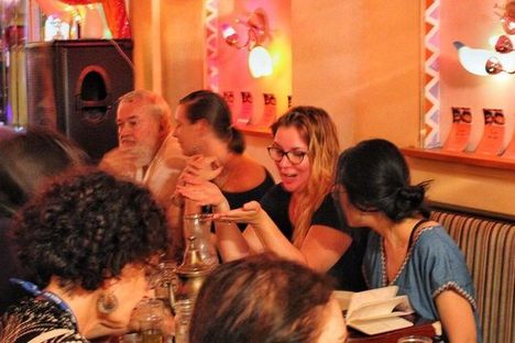 Attendees gather around a table to talk death at Tagine.