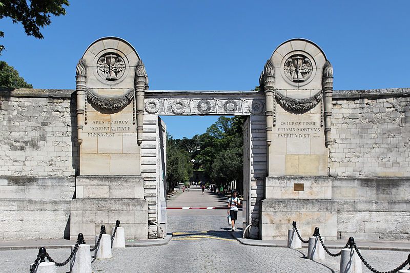 The colossal portal of Père Lachaise Cemetery in Paris and its winged hourglasses.