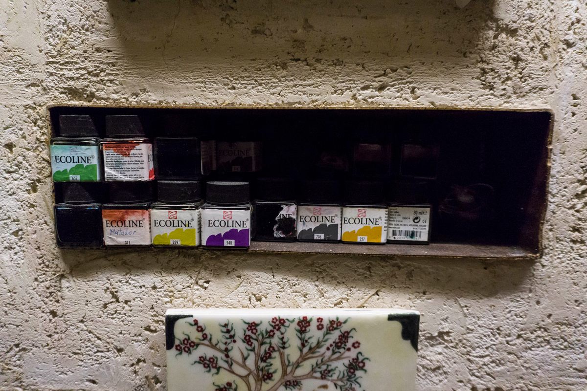 The paints Özek uses to create his shadow theater puppets sit in a recess on a wall in his small office.