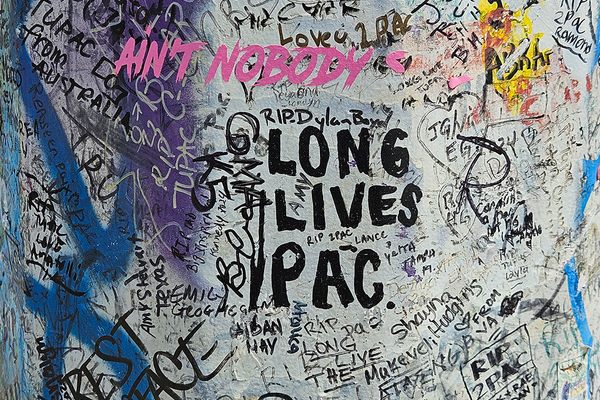 Graffiti on the utility pole pays homage to the late Tupac Shakur.