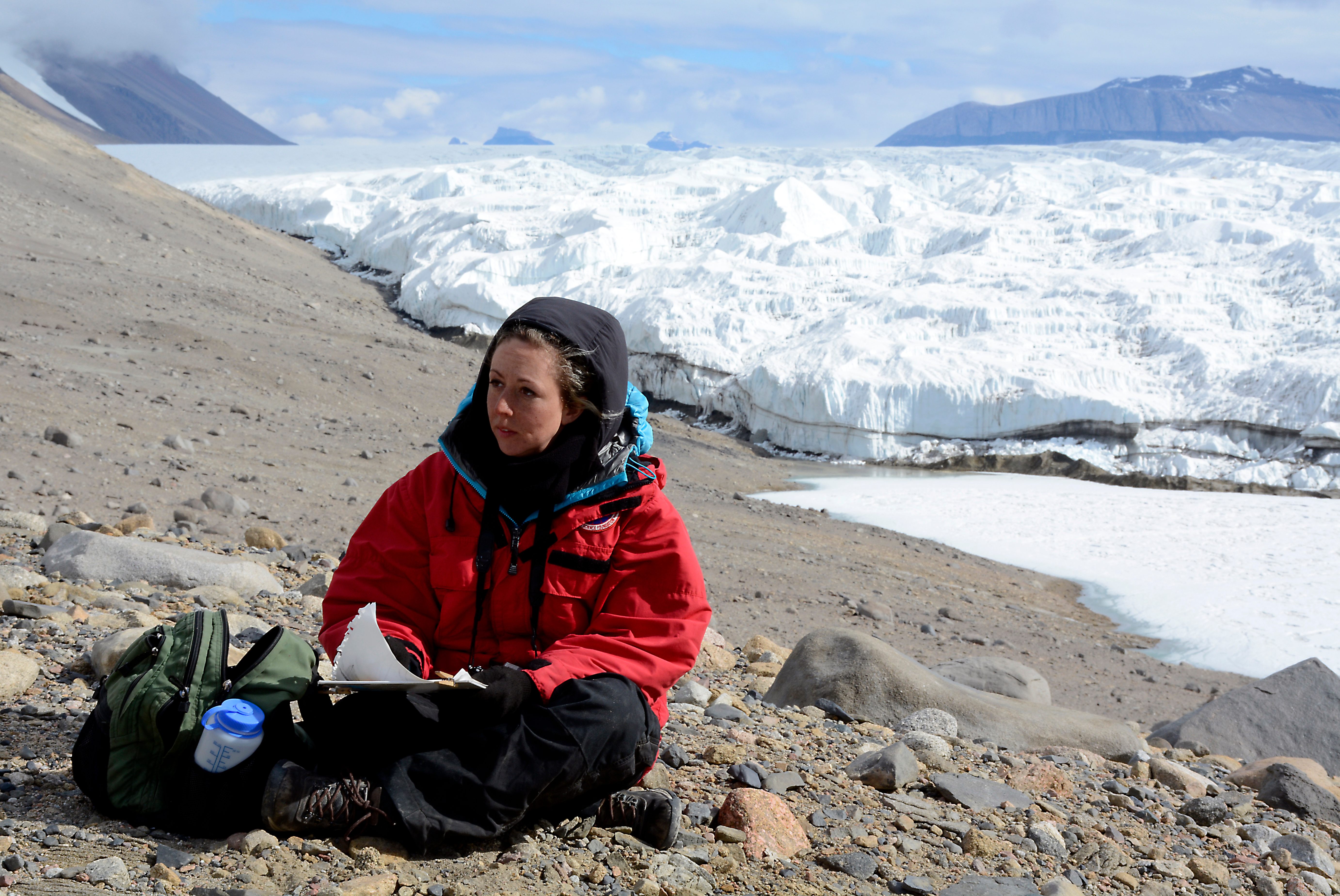 Lily Simonson in mid-sketch, next to a glacier.
