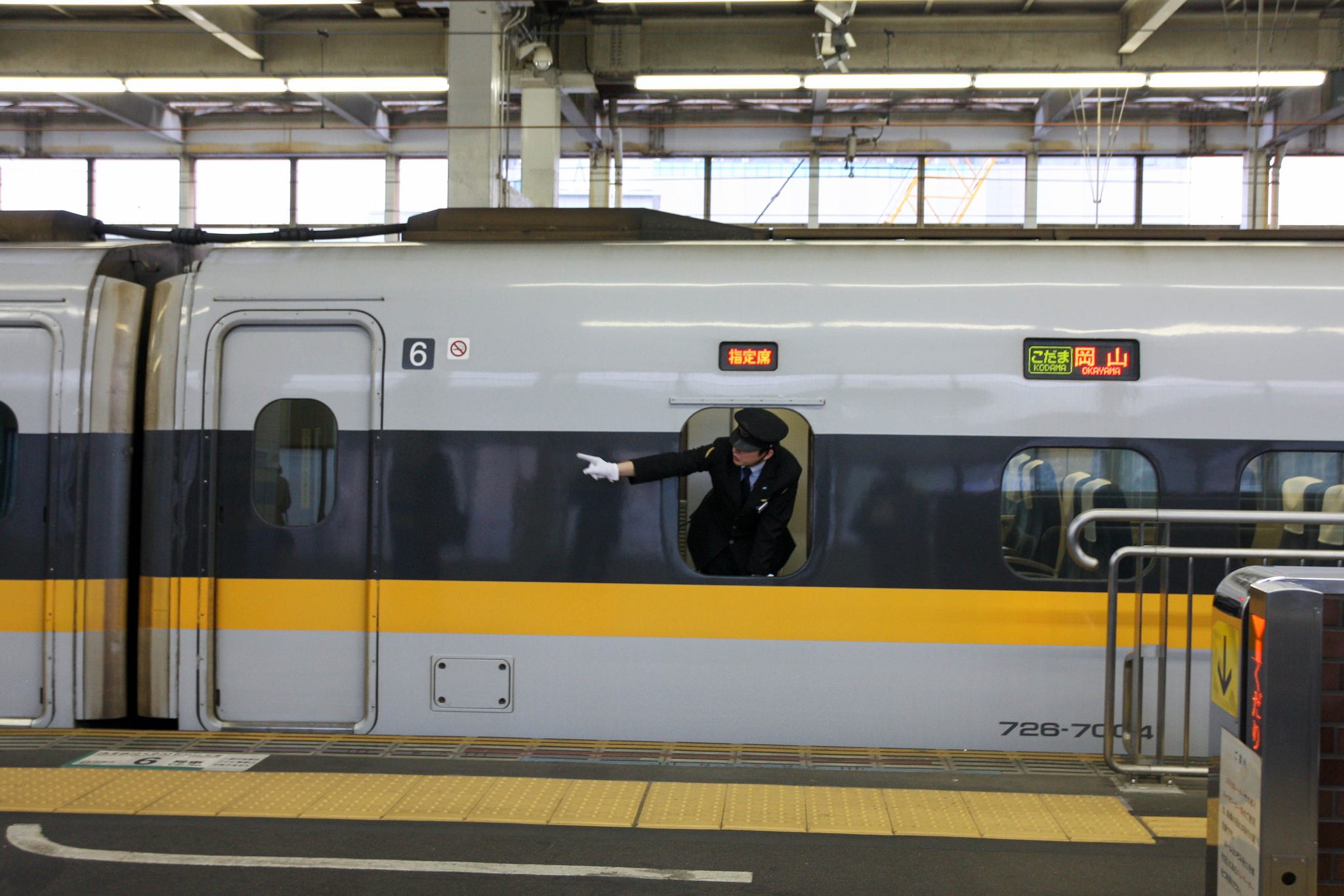 A Hiroshima train conductor pointing along the track.