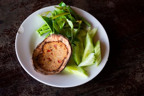 Crab meat and shrimp get pounded in a mortar and pestle with grated coconut, shrimp paste, chili and aromatics, smeared on the inside of a coconut shell and grilled until fragrant,