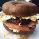 Taylor ham, sausage, egg, and cheese on a pumpernickel bagel.