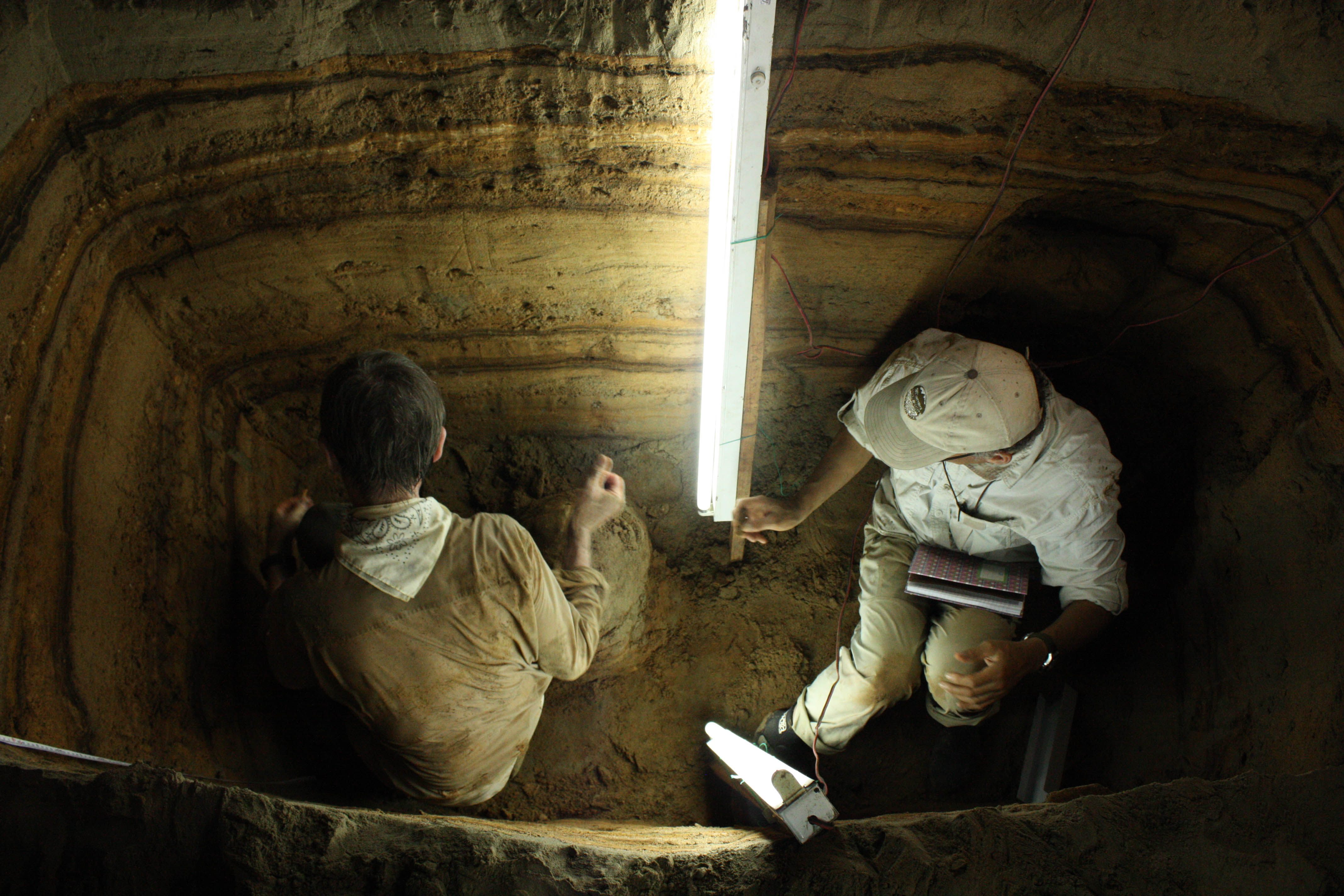 Researchers studying the layers of silt in an Indonesian cave. 