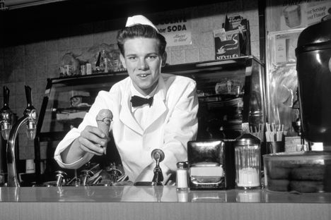 Soda jerks served sundaes and malts in white caps and jackets.