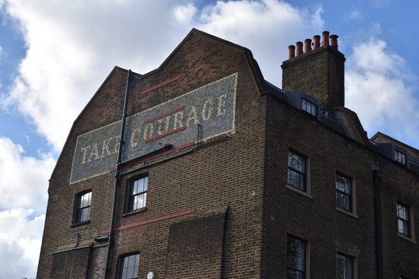 The sign seen here was an ad for Courage Brewery. 