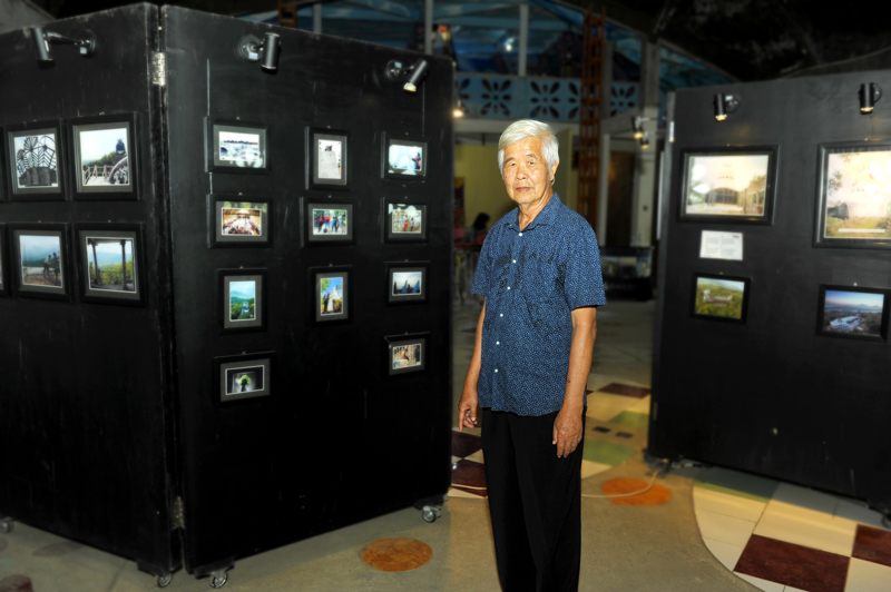 Daniel Alamsjah stands in front of the mini-museum in the center of the chicken church, which contains photos depicting the church's journey to completion.