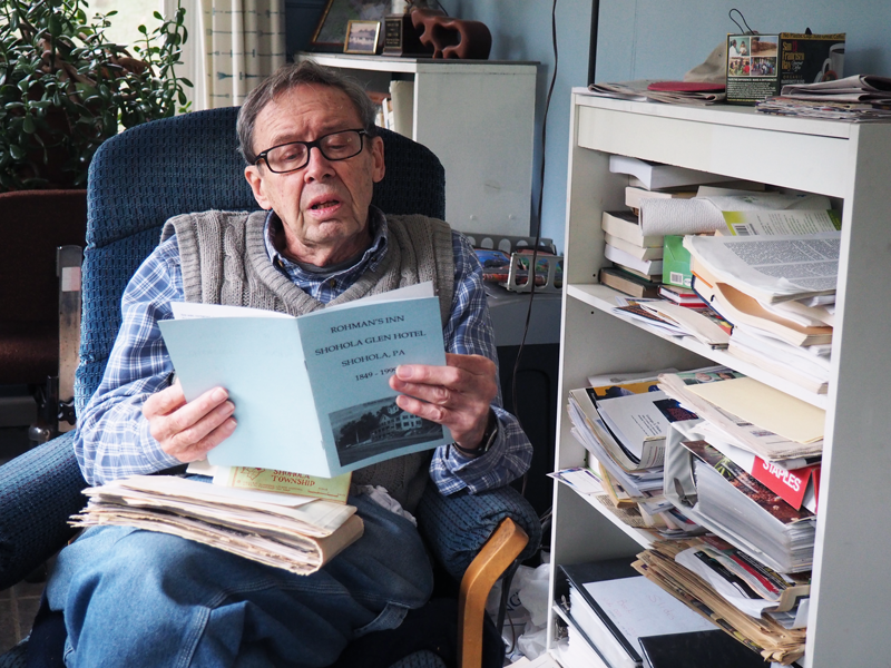 George Fluhr shows some of the pamphlets containing the history of the Inn and of its former owner, Art Rohman.