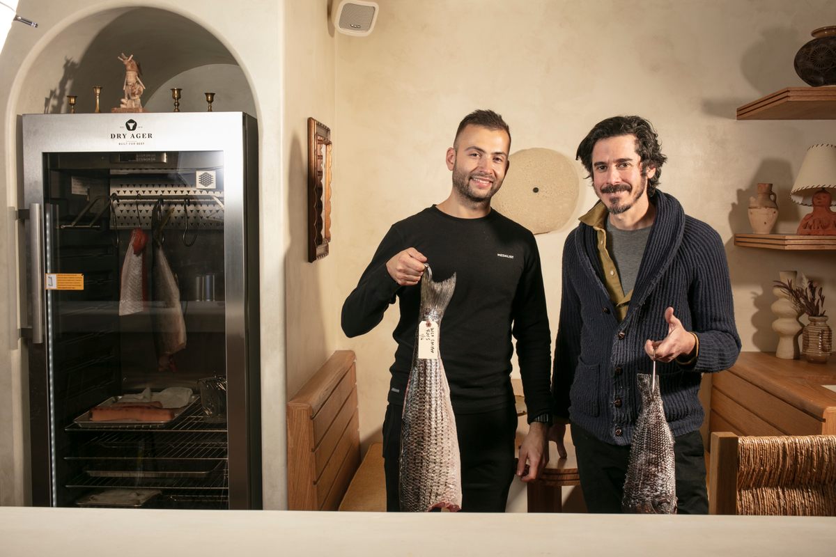 Blechman (right) stands in front of his dry-aging refrigerator.