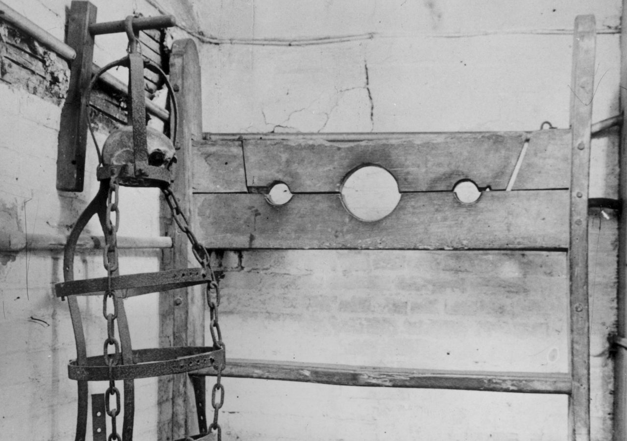 Gibbet irons and stocks on display in Winchelsea town hall in England. Within the gibbet there is a piece of skull belonging to the last man hanged in the equipment. 