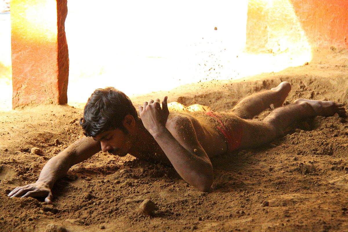 A pehlwan rubs mud over his body to create friction during wrestling sessions.
