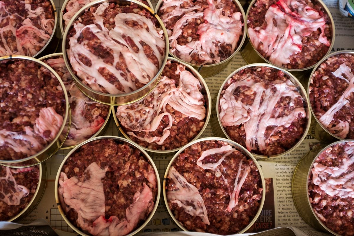Tins of pork pâté (seen from above) are assembled in the Bibal family kitchen before canning.