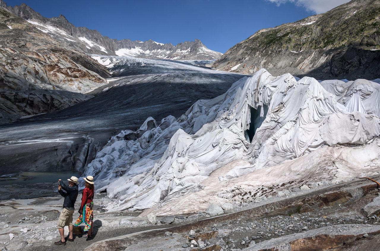 Visitors stand next to the Rhône glacier in August 2018.
