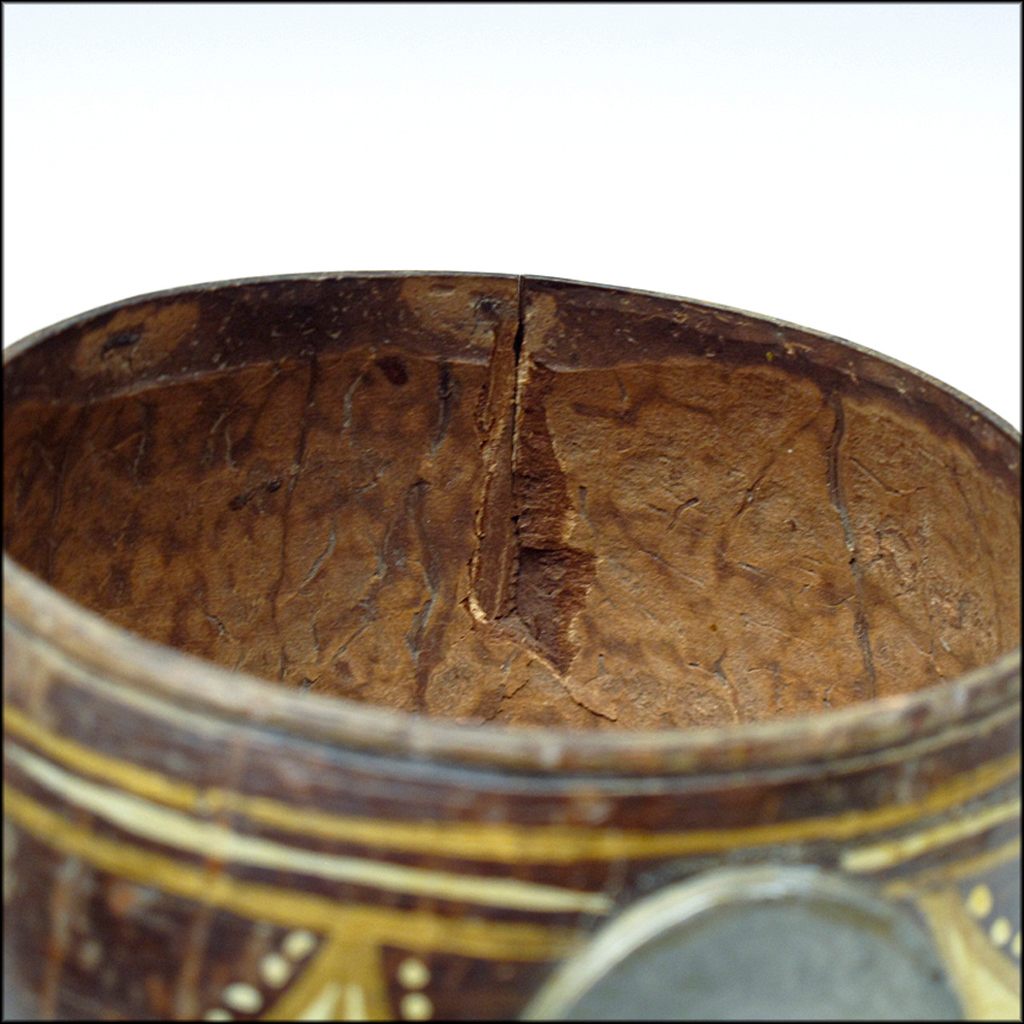 A close-up of an antique coconut dipper.