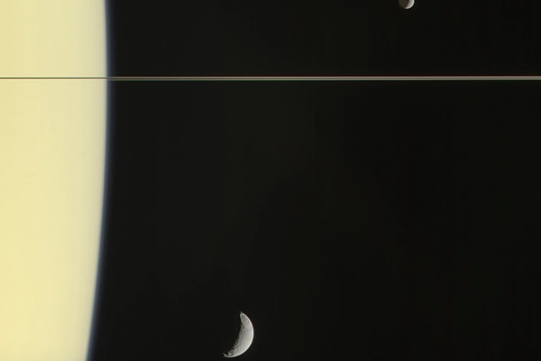 The Cassini spacecraft captured this nearly edge-on view of Saturn's rings and the moons Mimas, Janus, and Tethys. 