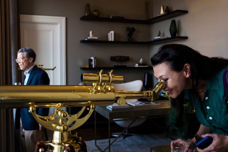 A guest takes a mapmaker's point of view, peeking through a telescope. 