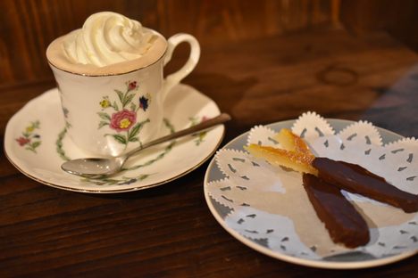 A cup of Viennese coffee with orangettes.