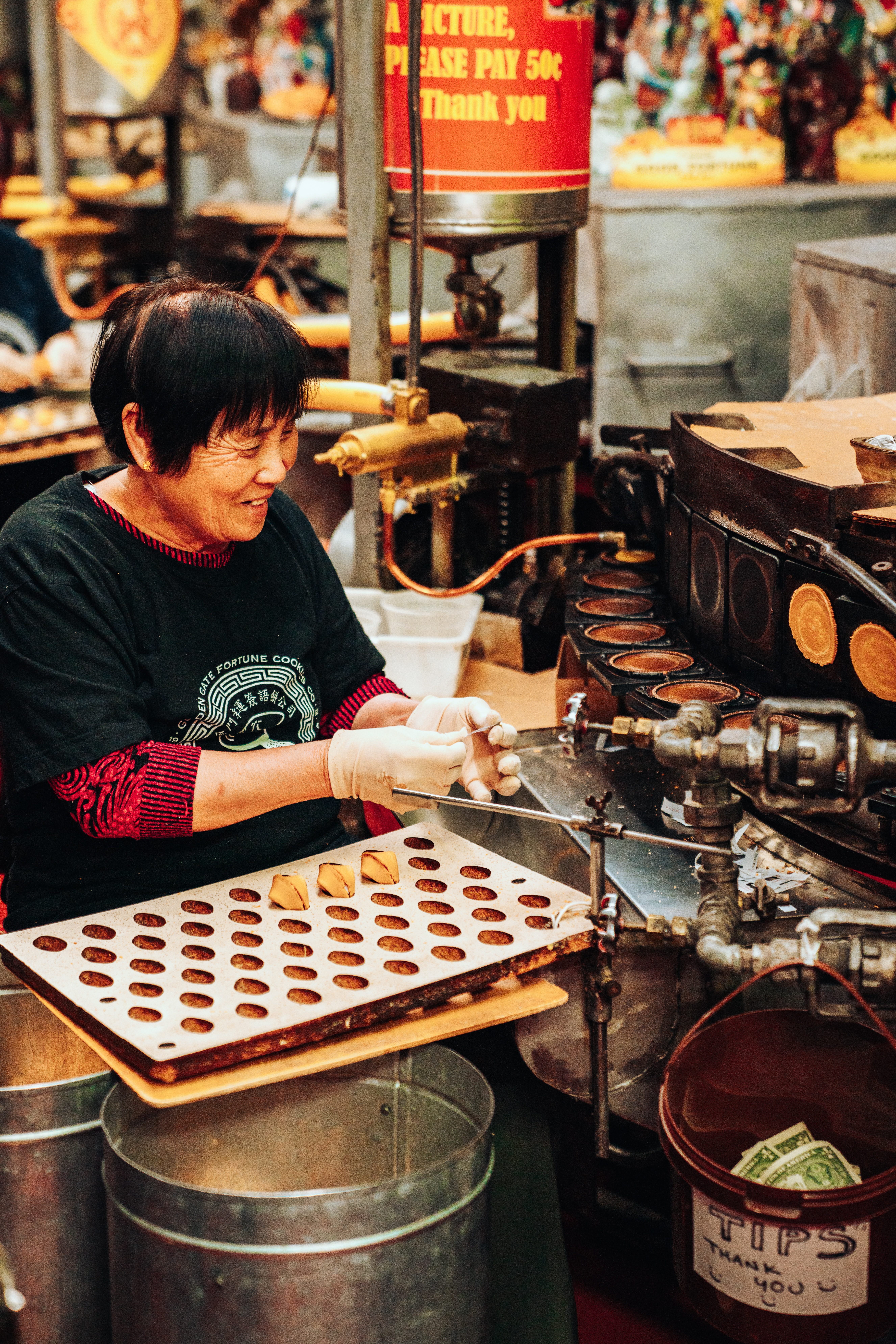 A woman makes fortune cookies—adopted by Chinese restaurants in response to Americans' expectations of dessert—at Golden Gate Fortune Cookie Factory in San Francisco.