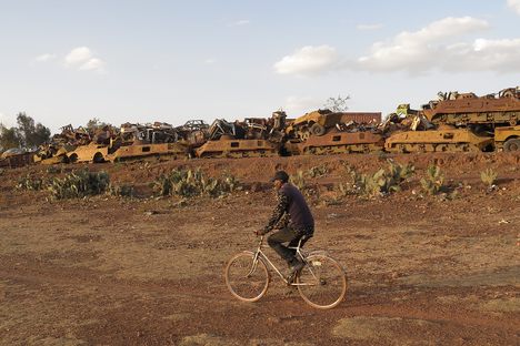 A cyclist rides past the tank graveyard in 2016.