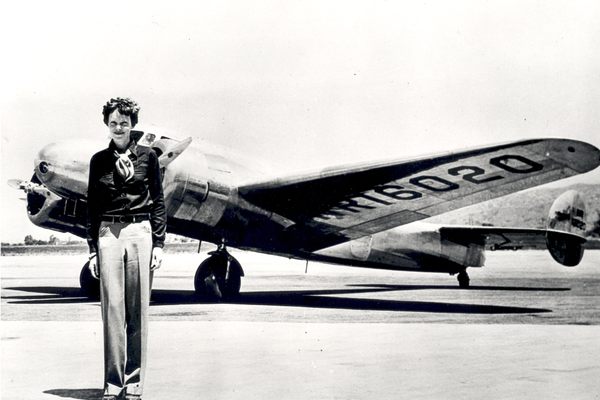 Earhart poses in front of the Lockheed Electra in which she disappeared in July 1937.