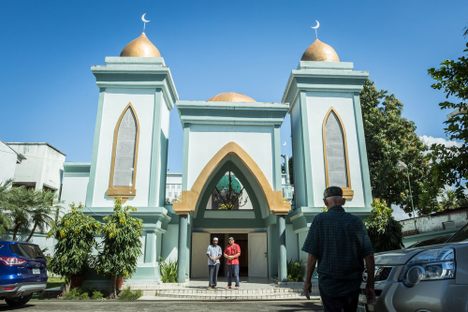 Men gather before Friday prayers in the parking lot outside the mosque in San Pedro Sula.