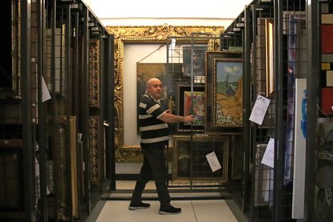 Giulio Iannarone, of the Carabinieri Tutela Patrimonio Culturale, slides out one of the racks of valuable paintings in the vault. 