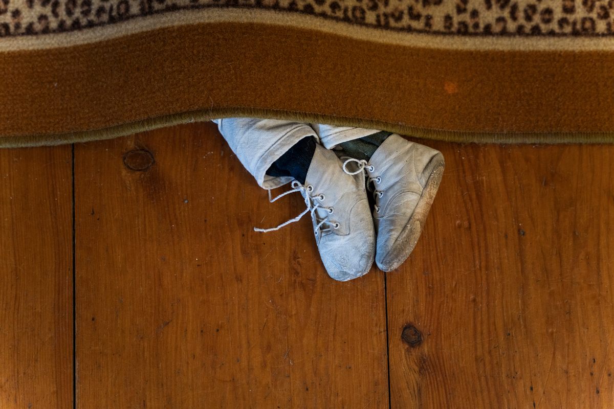 "G is for George smothered under a rug": A pair of legs poke out from under a rug, a reference to Gorey's <em>The Gashlycrumb Tinies</em>.