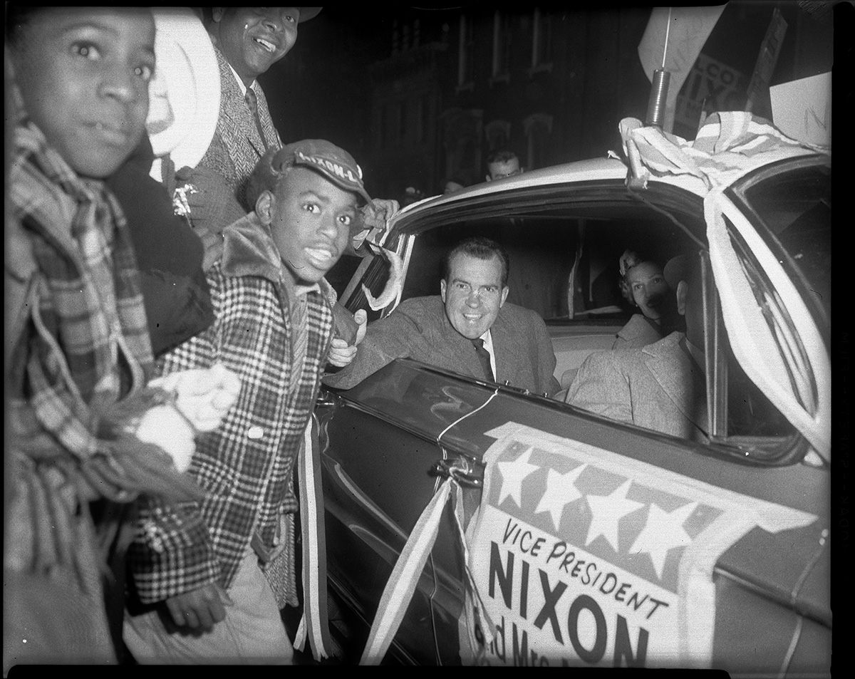 Vice President Richard Nixon and Pat Nixon greeting crowd from car, including Harold Irwin, Centre Avenue, Hill District, October 1960. 