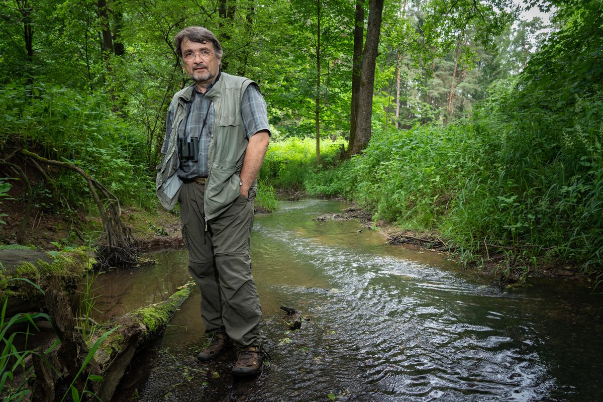 Kai Frobel standing in the border creek where he used to birdwatch a few hundred feet from an East German guard post.