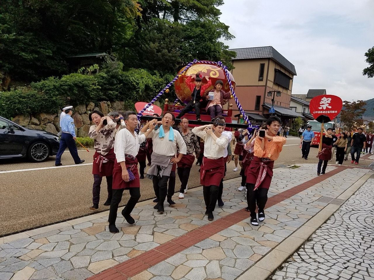 Takehito Nakajima, one of the leaders, blows his whistle to direct the bearers.