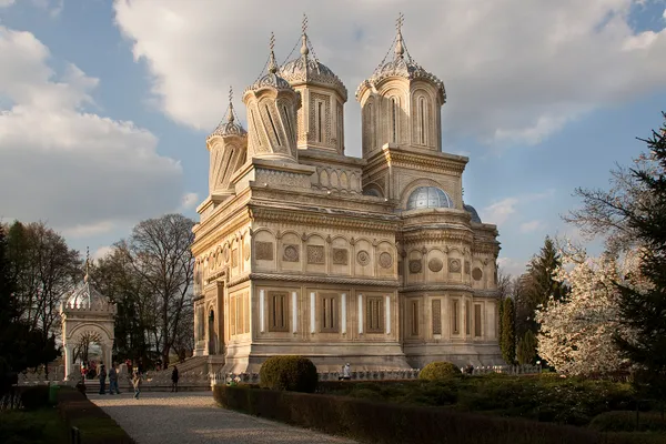 A white church with four small turrets, two of which appear to twist